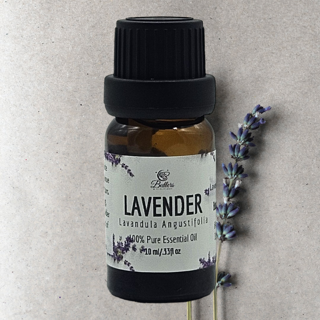 Bottle of lavender essential oil sitting next to a sprig  lavender flower