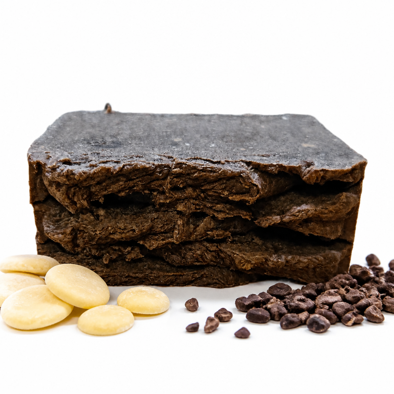 rectangle bar of african black soap sitting next to cacao nibs and cocoa butter