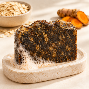 Taller turmeric and oatmeal soap bar with lightly orange-tinted lather
